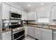 Stainless steel appliances and light gray cabinets in kitchen at 5569 Bougainvillea Ave, The Villages, FL 32163