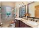 Elegant bathroom with double vanity, large mirrors, and a walk-in shower at 8455 River Branch Pl, Sanford, FL 32771