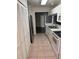 Galley kitchen featuring white cabinetry and stainless steel refrigerator at 12144 Bruceton Way # 101, Orlando, FL 32828