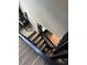 Carpeted staircase leads down with a dark wood railing to a tile floored landing and a peak of a chair at 12144 Bruceton Way # 101, Orlando, FL 32828