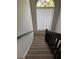 Carpeted stairwell with black railing leading to a window and a high ceiling at 12144 Bruceton Way # 101, Orlando, FL 32828