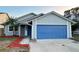 Gray house with blue garage door and red mulch at 1566 Lawndale Cir, Winter Park, FL 32792