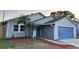 Newly renovated home with gray siding, blue door, and red mulch at 1566 Lawndale Cir, Winter Park, FL 32792