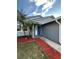 House entrance with blue door and red mulch landscaping at 1566 Lawndale Cir, Winter Park, FL 32792