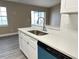 Well-lit kitchen showcasing stainless steel sink, white cabinets, and modern finishes at 1566 Lawndale Cir, Winter Park, FL 32792