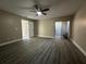 Living room features gray wood floors, a ceiling fan, and sliding door that opens to a lanai at 1566 Lawndale Cir, Winter Park, FL 32792