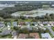 An aerial view shows the neighborhood homes near a serene lake with lush greenery at 20744 Queen Alexandra Dr, Leesburg, FL 34748