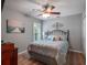 Bedroom with decorative bed, fan, and light wood-look flooring at 20744 Queen Alexandra Dr, Leesburg, FL 34748