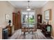 Bright dining area with a glass-top table, designer furnishings, and large window views to the outdoor landscaping at 20744 Queen Alexandra Dr, Leesburg, FL 34748