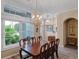 Elegant dining room with hardwood floors, decorative lighting, and a large window for natural light at 20744 Queen Alexandra Dr, Leesburg, FL 34748