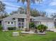 Inviting home showcasing manicured landscaping, a decorative front gate, and an attached two-car garage at 20744 Queen Alexandra Dr, Leesburg, FL 34748