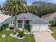 Beautiful single-story home with a well-manicured lawn, mature landscaping, and a spacious two-car garage at 20744 Queen Alexandra Dr, Leesburg, FL 34748