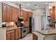 Well-lit kitchen featuring granite countertops, stainless steel appliances, and wood cabinets at 20744 Queen Alexandra Dr, Leesburg, FL 34748