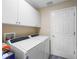 Bright laundry room features a modern washer and dryer and plenty of storage at 20744 Queen Alexandra Dr, Leesburg, FL 34748