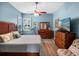 Light-filled main bedroom with wooden furniture, a ceiling fan, and wood-look floors at 20744 Queen Alexandra Dr, Leesburg, FL 34748