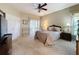 Spacious bedroom with a ceiling fan, carpet, and access to a private patio at 2211 Stonebridge Way, Clermont, FL 34711