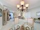 Open dining room with a glass-top table and chairs, offering a view of the living room and entryway at 2211 Stonebridge Way, Clermont, FL 34711