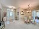 Bright dining room with a glass-top table, chandelier, and four chairs, near the entryway at 2211 Stonebridge Way, Clermont, FL 34711