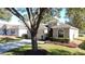 One-story house with attached garage and landscaping, large tree in front at 2211 Stonebridge Way, Clermont, FL 34711