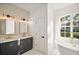 Luxury bathroom featuring a soaking tub, double vanity, with mosaic tile and premium fixtures at 23503 Valderama Ln, Sorrento, FL 32776