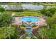 Stunning community pool area with lush landscaping and serene lake views from above at 3530 Mulberry Grove Loop, Leesburg, FL 34748