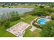 Aerial view of shuffleboard courts, community pool, and a scenic lake at 3530 Mulberry Grove Loop, Leesburg, FL 34748