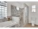 Spa-like bathroom with a soaking tub, glass block window and a separate marbled shower at 3530 Mulberry Grove Loop, Leesburg, FL 34748