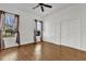 A bedroom with wood flooring, neutral walls, natural light, and closet space at 3530 Mulberry Grove Loop, Leesburg, FL 34748