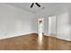 Bedroom featuring wood flooring, neutral walls, ceiling fan and view into the living room at 3530 Mulberry Grove Loop, Leesburg, FL 34748