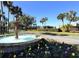 Community entrance with a tiered water fountain and colorful flower beds on a clear day at 3530 Mulberry Grove Loop, Leesburg, FL 34748