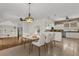 Elegant dining room with a decorative light fixture adjoining a kitchen with stainless steel appliances at 3530 Mulberry Grove Loop, Leesburg, FL 34748