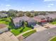 Well-manicured home exterior featuring a spacious driveway and lush lawn with an American flag at 3530 Mulberry Grove Loop, Leesburg, FL 34748