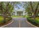 Stately clubhouse framed by grand trees and a circular driveway, creating a luxurious entrance at 3530 Mulberry Grove Loop, Leesburg, FL 34748