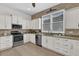 Modern kitchen with white cabinets, stainless steel appliances, and granite countertops at 3530 Mulberry Grove Loop, Leesburg, FL 34748