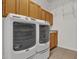 This laundry room has front-loading washer and dryer with wooden cabinetry at 3530 Mulberry Grove Loop, Leesburg, FL 34748