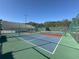 Blue and red tennis courts with green surroundings, showing a well-maintained recreational area at 3530 Mulberry Grove Loop, Leesburg, FL 34748