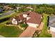 House with brown roof, red door and landscaped yard at 38728 Oak Place Ct, Lady Lake, FL 32159