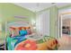 Bedroom with white bed frame, colorful bedding, and view into another room at 38728 Oak Place Ct, Lady Lake, FL 32159