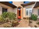 Inviting entryway with a red door and well-manicured landscaping at 38728 Oak Place Ct, Lady Lake, FL 32159