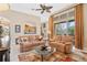 Spacious living room with beige sofas, a ceiling fan and large windows at 38728 Oak Place Ct, Lady Lake, FL 32159