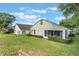 A well-maintained backyard with a screened-in porch, manicured hedges, and green lawn under a blue sky at 4130 Capland Ave, Clermont, FL 34711
