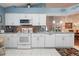 Bright kitchen with white cabinetry, granite countertops, and stainless steel appliances offers a modern space for cooking at 4130 Capland Ave, Clermont, FL 34711