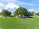 Landscaped front yard with lush green grass and mature trees at 1315 Greenville Way, The Villages, FL 32162