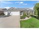 Three-car garage, gray siding, and nicely landscaped front yard at 1315 Greenville Way, The Villages, FL 32162