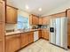 Kitchen with wood cabinets, stainless steel refrigerator, and white stove at 1415 E 9Th Ave, Mount Dora, FL 32757