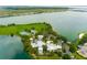 Aerial view featuring community amenities including a pool, tennis courts, and playground all adjacent to a beautiful lake at 561 Juniper Springs Dr, Groveland, FL 34736