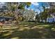 Expansive backyard featuring mature trees and lush green grass, great for entertaining at 1214 Loch Rannoch Ct, Leesburg, FL 34788