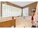 Bright bathroom showcasing a garden tub, glass block windows, and neutral countertops at 1214 Loch Rannoch Ct, Leesburg, FL 34788