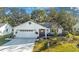 White single-story house with a landscaped yard and attached garage at 1214 Loch Rannoch Ct, Leesburg, FL 34788
