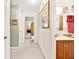 Well-lit hallway leading to rooms, complemented by neutral tones and bathroom with updated vanity at 1214 Loch Rannoch Ct, Leesburg, FL 34788